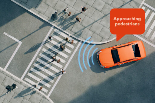 Aerial view of an orange car at a crosswalk detecting nearby pedestrians, with blue waves showing sensor activity and a speech bubble saying Approaching pedestrians..